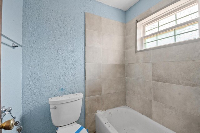 5401 Bayou Dr, Dickinson, TX 77539 - bathroom featuring toilet, a textured wall, a shower, and a washtub