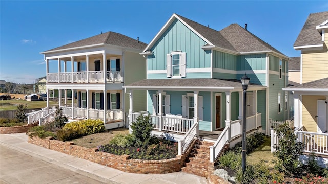 4 Caravelle Ct, Galveston, TX 77554 - view of front of house featuring covered porch, board and batten siding, a balcony, and a shingled roof