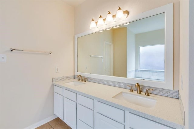 full bathroom with double vanity, a sink, tile patterned floors, and baseboards