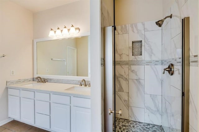 bathroom featuring double vanity, a sink, and a shower stall