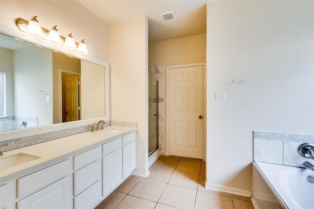 full bath featuring a stall shower, tile patterned floors, visible vents, and a sink