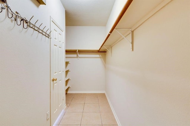 walk in closet with light tile patterned flooring