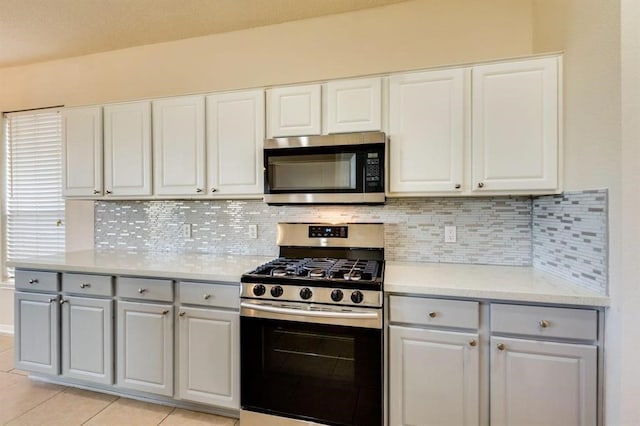 kitchen featuring backsplash, gray cabinets, and appliances with stainless steel finishes