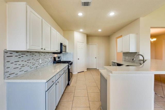 kitchen with light tile patterned floors, stainless steel appliances, a sink, visible vents, and a peninsula