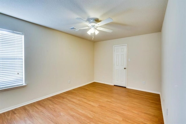 unfurnished room with baseboards, a textured ceiling, ceiling fan, and light wood-type flooring