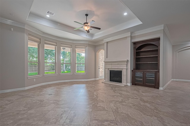 4210 Wentworth Dr, Fulshear, TX 77441 - unfurnished living room featuring a ceiling fan, a glass covered fireplace, a tray ceiling, baseboards, and ornamental molding