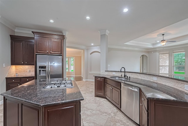 4210 Wentworth Dr, Fulshear, TX 77441 - kitchen with stainless steel appliances, a sink, a center island, decorative backsplash, and arched walkways