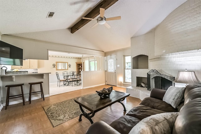 9610 Twin Oaks Dr, Manvel, TX 77578 - living area with lofted ceiling with beams, ceiling fan, light wood finished floors, a brick fireplace, and visible vents