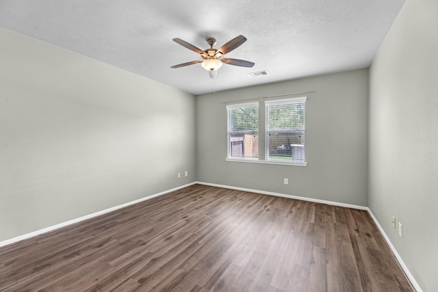 4810 Legends Bay Dr, Baytown, TX 77523 - empty room featuring dark wood-style flooring, ceiling fan, a textured ceiling, baseboards, and visible vents