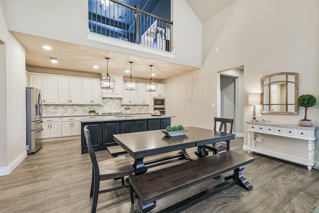 20207 Desert Foal Dr, Tomball, TX 77377 - dining area with a towering ceiling, light wood-type flooring, and baseboards