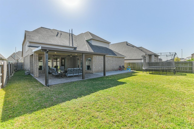 20207 Desert Foal Dr, Tomball, TX 77377 - back of property featuring a trampoline, a ceiling fan, a patio area, brick siding, and roof with shingles