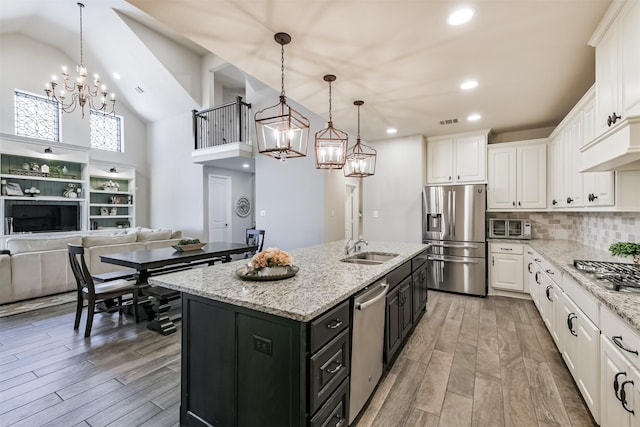 20207 Desert Foal Dr, Tomball, TX 77377 - kitchen with appliances with stainless steel finishes, a chandelier, white cabinets, dark cabinetry, and a sink