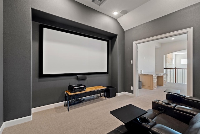 cinema room with baseboards, visible vents, vaulted ceiling, and light colored carpet