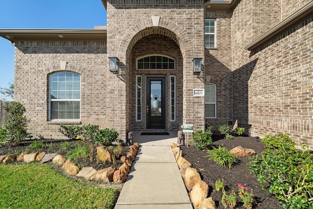 view of exterior entry with brick siding