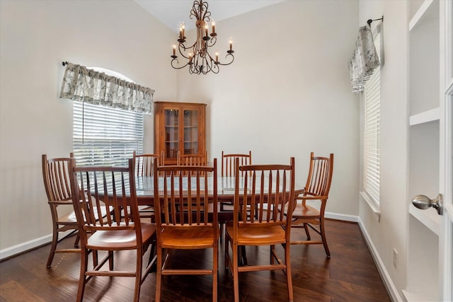 dining area featuring an inviting chandelier, baseboards, and wood finished floors