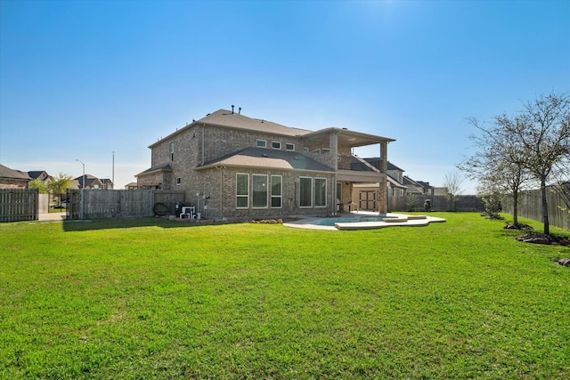 back of house featuring a fenced backyard, a patio, brick siding, and a lawn