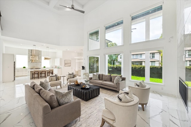 4670 Cedar St, Bellaire, TX 77401 - living area with a towering ceiling, light marble finish flooring, a ceiling fan, healthy amount of natural light, and beam ceiling