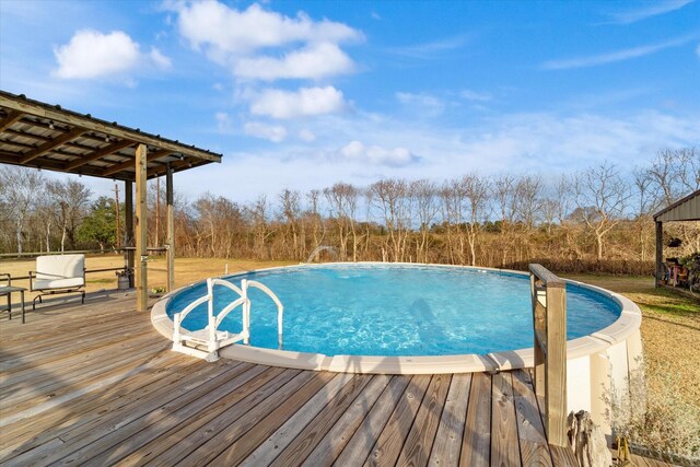 outdoor pool featuring a lawn and a wooden deck