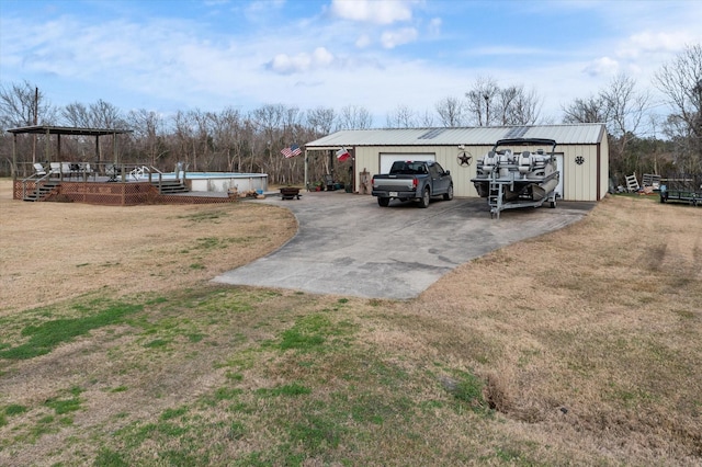 view of yard with an outdoor structure, an outdoor pool, driveway, and a gazebo