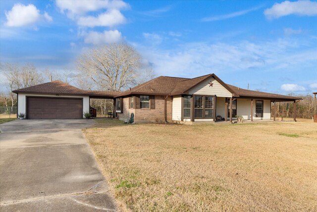 single story home featuring driveway, a garage, roof with shingles, and a front lawn