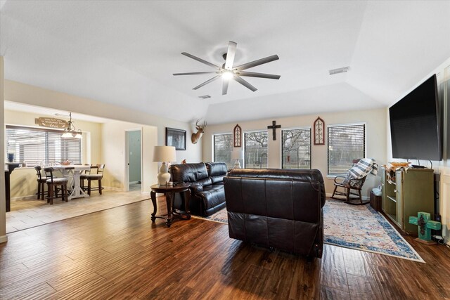 living room with vaulted ceiling, a ceiling fan, wood finished floors, baseboards, and visible vents