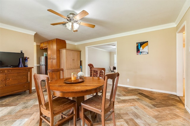dining space featuring baseboards, crown molding, and a ceiling fan