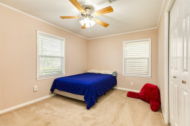 carpeted bedroom with baseboards, a ceiling fan, and crown molding