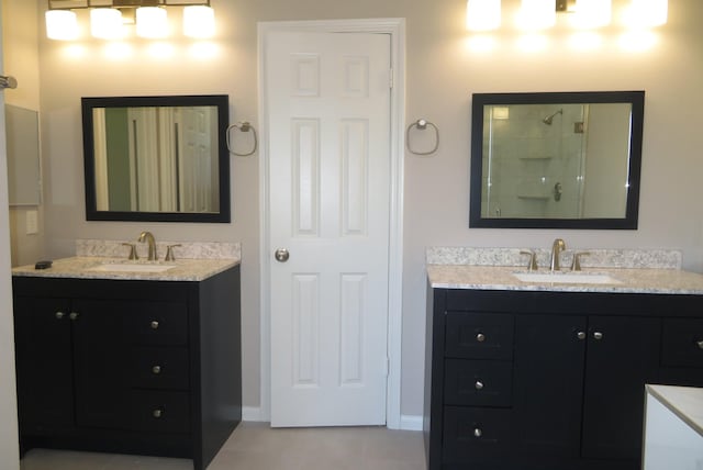 1606 Caslyn Dr, Rosenberg, TX 77471 - bathroom with two vanities, a tile shower, tile patterned floors, and baseboards