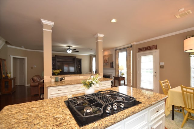 4242 Noble Oak Trl, Houston, TX 77059 - kitchen with black gas cooktop, ornate columns, a ceiling fan, ornamental molding, and light stone counters