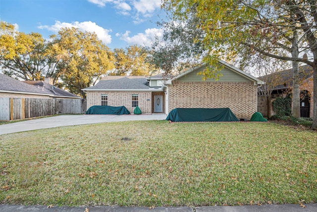 ranch-style house featuring brick siding, fence, a front lawn, and a patio area