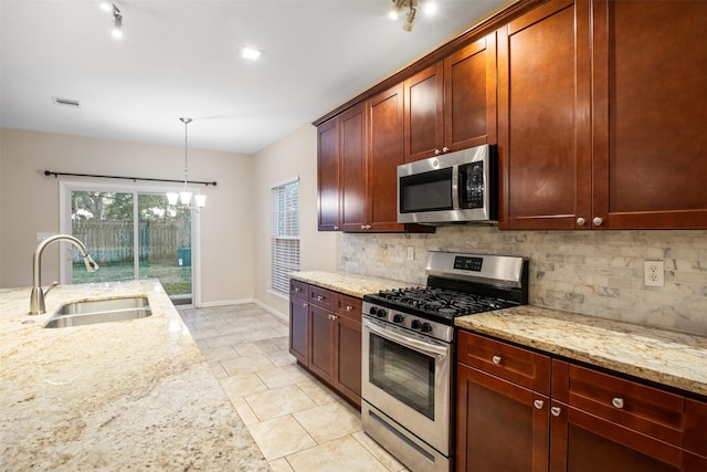kitchen with stainless steel appliances, decorative backsplash, a sink, light stone counters, and visible vents