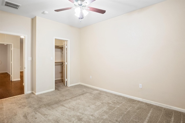 unfurnished bedroom with baseboards, visible vents, a spacious closet, and carpet flooring
