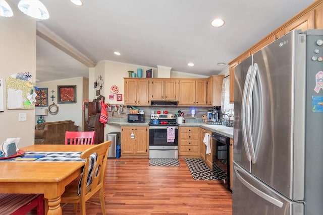 kitchen with light wood-type flooring, light countertops, black appliances, exhaust hood, and vaulted ceiling