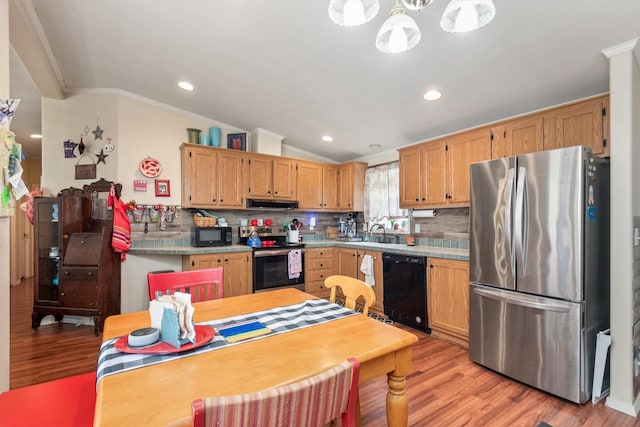 kitchen featuring decorative backsplash, black appliances, light wood finished floors, and extractor fan