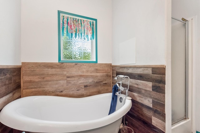 bathroom with a shower with door and a freestanding bath