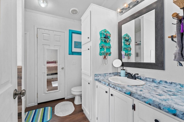 bathroom featuring crown molding, vanity, toilet, and wood finished floors