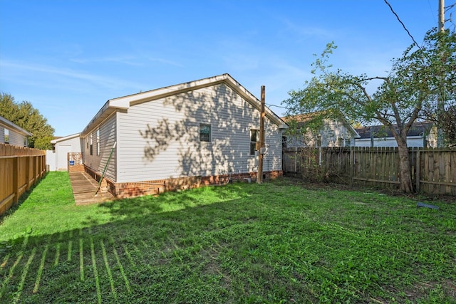 rear view of house with a fenced backyard and a yard
