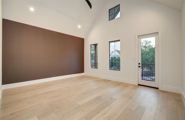 unfurnished room with a healthy amount of sunlight, high vaulted ceiling, recessed lighting, and light wood finished floors