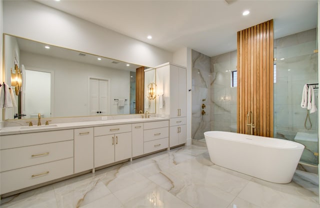 bathroom featuring double vanity, a shower stall, a sink, marble finish floor, and recessed lighting