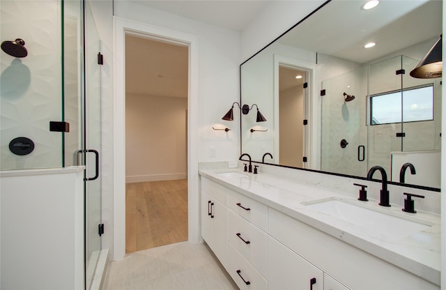 bathroom with recessed lighting, a sink, and a stall shower
