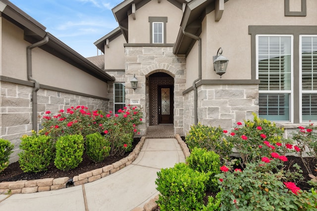 doorway to property with stucco siding and stone siding