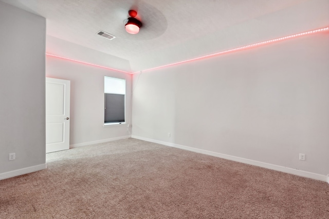 carpeted spare room featuring baseboards and visible vents