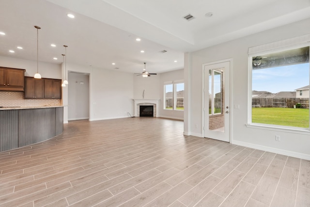unfurnished living room with a fireplace, visible vents, recessed lighting, and light wood finished floors