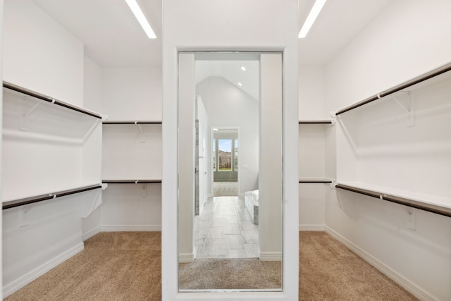 spacious closet featuring lofted ceiling and carpet