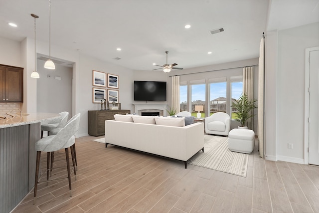 living area featuring light wood finished floors, visible vents, ceiling fan, and recessed lighting