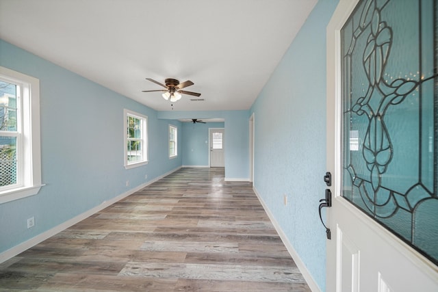 entryway featuring baseboards, a ceiling fan, and wood finished floors