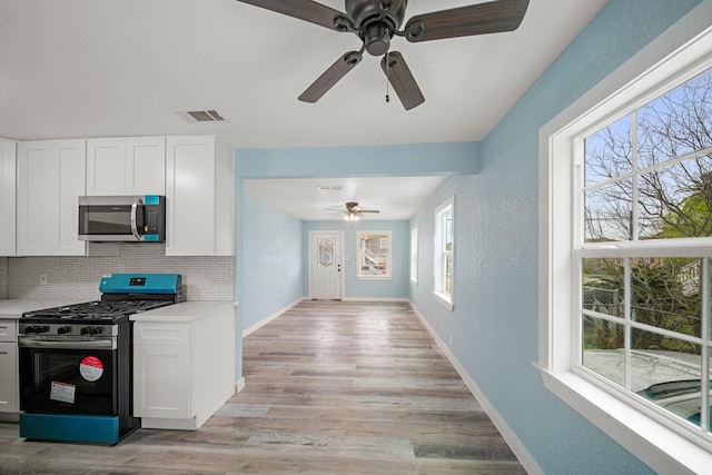 kitchen featuring light countertops, appliances with stainless steel finishes, a ceiling fan, and visible vents