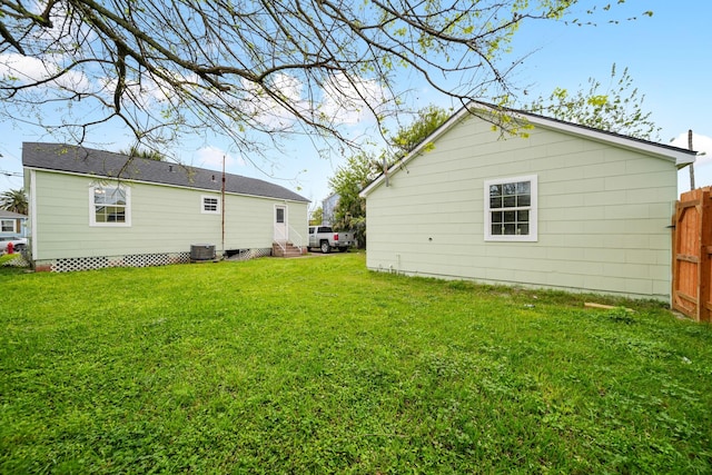 back of house featuring a lawn, fence, and entry steps
