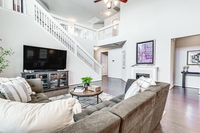 1100 Lasso Ct, Alvin, TX 77511 - living area featuring a ceiling fan, wood finished floors, stairs, a high ceiling, and visible vents
