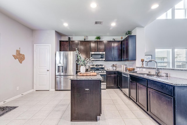 1100 Lasso Ct, Alvin, TX 77511 - kitchen with a center island, tasteful backsplash, a sink, stainless steel appliances, and light stone countertops